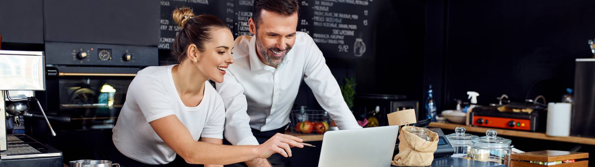 Two restaurant owners reviewing finances on a laptop