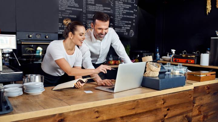 Two restaurant owners reviewing finances on a laptop
