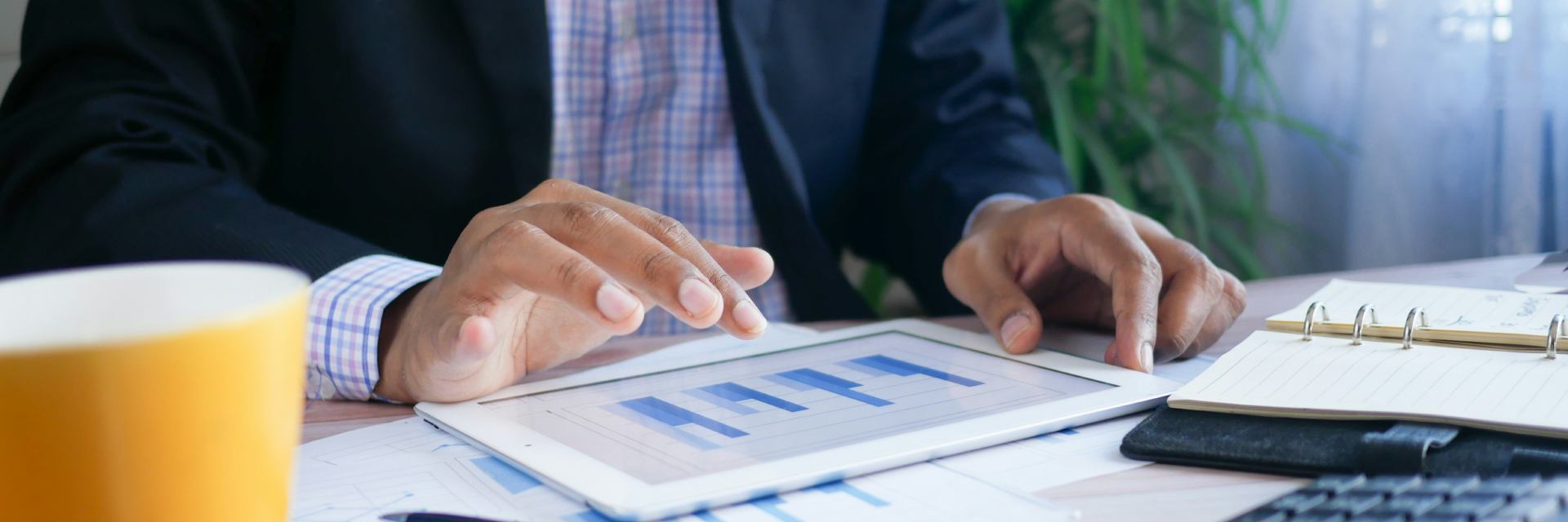 Man looking at tablet device showing financial reports