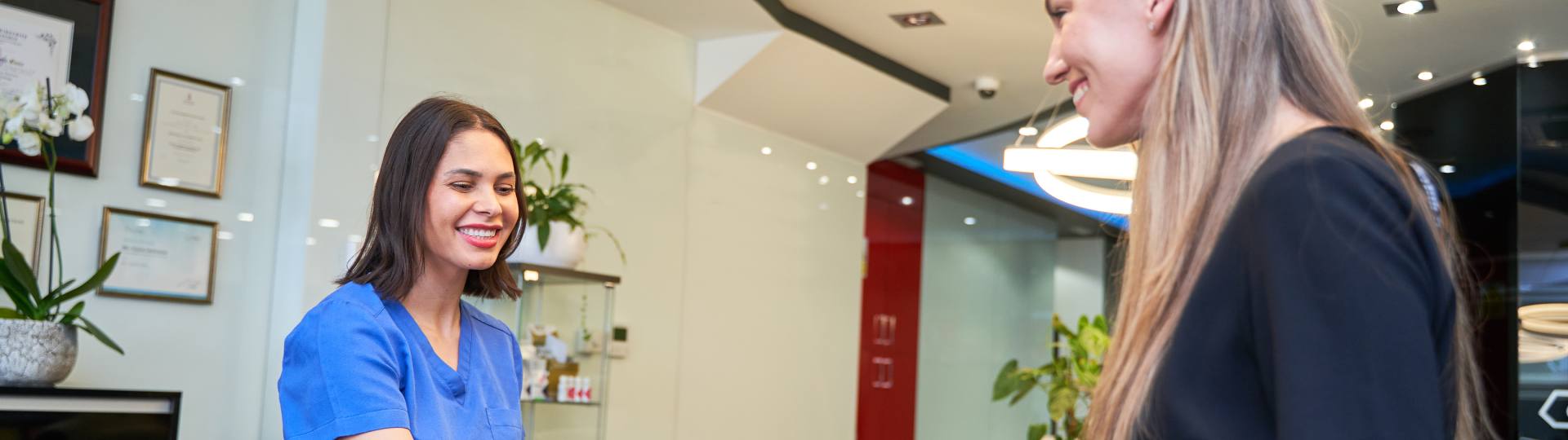 Receptionist at dental office talking to a patient