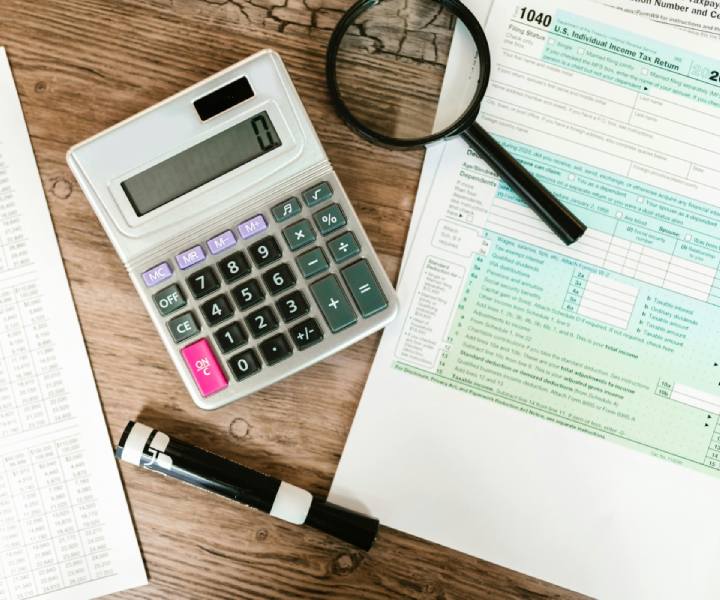 Tax papers with a calculator and magnifying glass