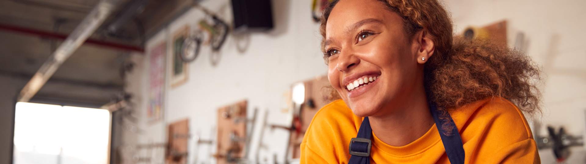 Small business owner leaning on her store counter smiling