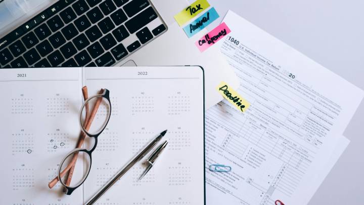 Business papers and notebook laying next to a laptop