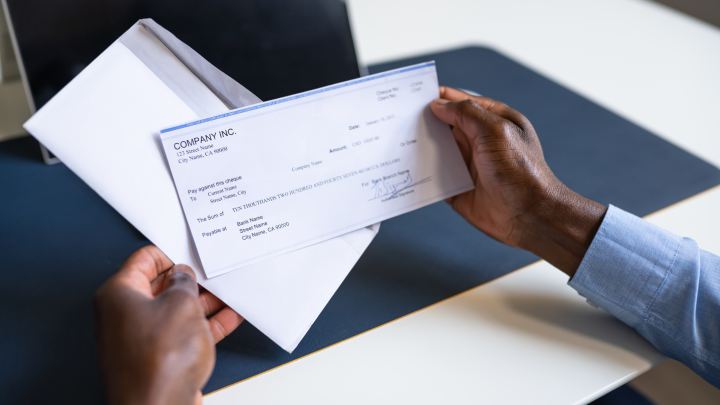 Hands opening up a paycheck
